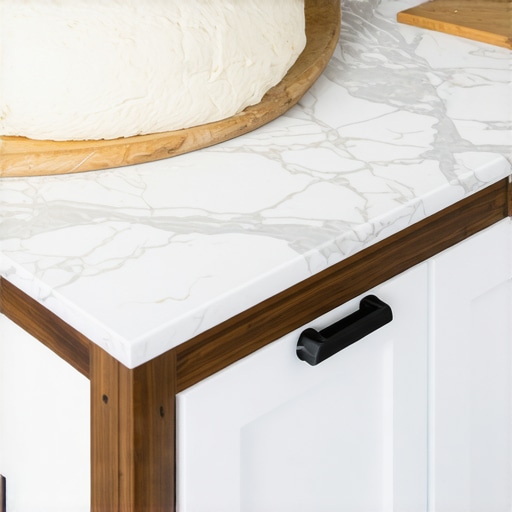 A kitchen island featuring a lower section specifically designed for ergonomic baking and dough rolling.